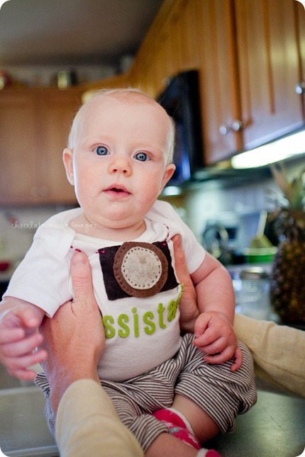 Little Charlotte models the assistant onesie showing her excitement to assist Chocolate Moose Images